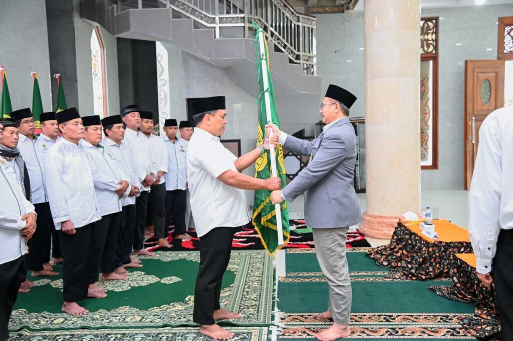 Ketua DPD LDII Kab. berau terpilih Akhmad Yudiansyah menerima bendera pataka dari Prof. Candra sebagai simbol pergantian kepemimpinan yang baru. Foto: LINES