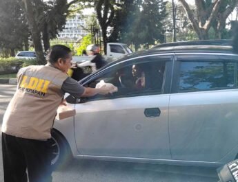 Ketua PC LDII Kec. Balikpapan Selatan sedang berbaji takjil pada pengguna jalan di Jalan Marsma Iswahyudi Balikpapan, Minggu (9/3/2025). Foto: LINES