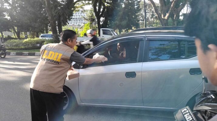 Ketua PC LDII Kec. Balikpapan Selatan sedang berbaji takjil pada pengguna jalan di Jalan Marsma Iswahyudi Balikpapan, Minggu (9/3/2025). Foto: LINES